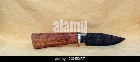 Ein wunderschönes handgefertigtes Messer mit fester Klinge, einer wunderschönen damaskus-Klinge und einem schönen Holzgriff. Das Messer ist sowohl hübsch als auch funktional. Stockfoto