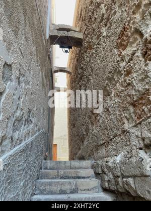 Enge Gasse zwischen den Mauern von Gebäuden im historischen Zentrum von Monopoli, Italien Stockfoto