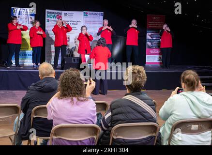 Tag Des Bewusstseins Für Behinderte 2024. Warrington BSL Signing Chor trat auf der Bühne auf Stockfoto