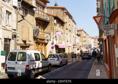Langeac, Frankreich - 28. Mai 2023: Eine enge Straße, gesäumt von charmanten Steinhäusern in Langeac, Frankreich, mit einem weißen Van auf der linken Seite. Stockfoto