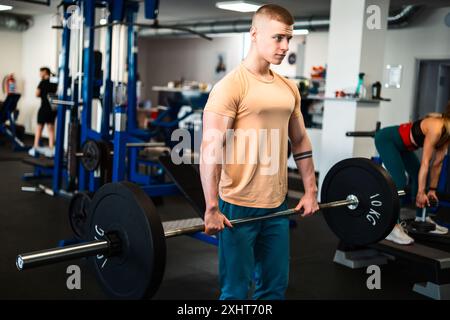 Ein männlicher Bodybuilder führt eine Gewichtheben-Übung in einem Fitnessstudio durch Stockfoto