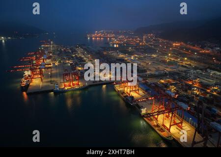 LIANYUNGANG, CHINA - 15. JULI 2024 - Frachtschiffe entladen Container am Containerterminal des Hafens Lianyungang, Provinz Jiangsu im Osten Chinas, Juli Stockfoto
