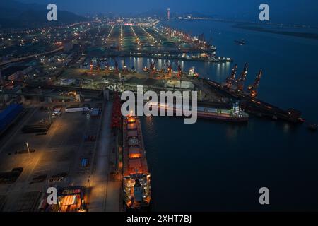 LIANYUNGANG, CHINA - 15. JULI 2024 - Frachtschiffe entladen Container am Containerterminal des Hafens Lianyungang, Provinz Jiangsu im Osten Chinas, Juli Stockfoto