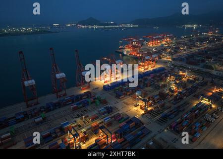 LIANYUNGANG, CHINA - 15. JULI 2024 - Frachtschiffe entladen Container am Containerterminal des Hafens Lianyungang, Provinz Jiangsu im Osten Chinas, Juli Stockfoto