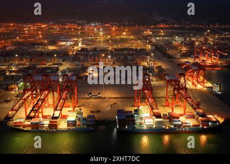LIANYUNGANG, CHINA - 15. JULI 2024 - Frachtschiffe entladen Container am Containerterminal des Hafens Lianyungang, Provinz Jiangsu im Osten Chinas, Juli Stockfoto