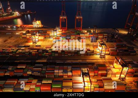 LIANYUNGANG, CHINA - 15. JULI 2024 - Frachtschiffe entladen Container am Containerterminal des Hafens Lianyungang, Provinz Jiangsu im Osten Chinas, Juli Stockfoto