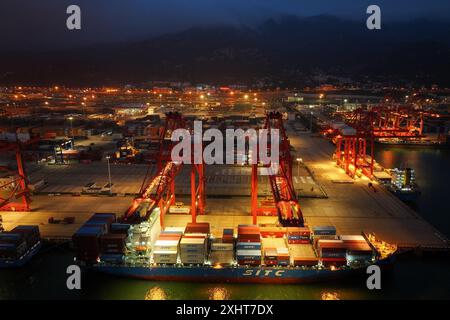 LIANYUNGANG, CHINA - 15. JULI 2024 - Frachtschiffe entladen Container am Containerterminal des Hafens Lianyungang, Provinz Jiangsu im Osten Chinas, Juli Stockfoto