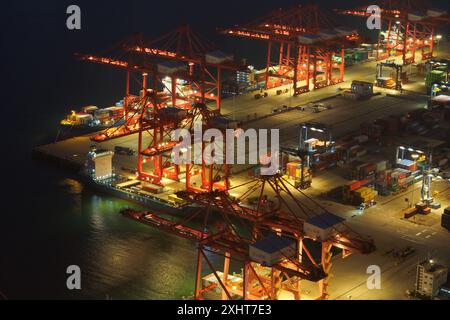 LIANYUNGANG, CHINA - 15. JULI 2024 - Frachtschiffe entladen Container am Containerterminal des Hafens Lianyungang, Provinz Jiangsu im Osten Chinas, Juli Stockfoto