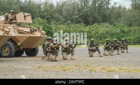 Peruanische Marineinfanterie-Marineinfanterie und malaysische Soldaten, die dem 8. Bataillon (Para), dem Royal Ranger Regiment, der 10. Fallschirmbrigade, zugewiesen wurden, halten eine Sicherheitsposition, nachdem sie in ein mechanisches Infanterie-Tauchtraining auf dem Marinekorps-Trainingsgebiet Bellows, Waimanalo, Hawaii, während der Übung Rim of the Pacific (RIMPAC) 2024, 13. Juli, eingesetzt wurden. 29 Nationen, 40 Überlandschiffe, drei U-Boote, 14 nationale Landstreitkräfte, mehr als 150 Flugzeuge und 25.000 Mitarbeiter nehmen vom 27. Juni bis 1. August auf den hawaiianischen Inseln Teil. Die weltweit größte internationale maritime Übung; RIMPAC Stockfoto