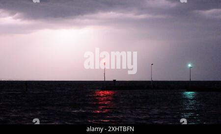 Deutschland kommt nicht zur Ruhe. Abermals sind schwere Gewitter und Unwetter über Süddeutschland hinweggezogen. Am Abend formierte sich am Bodensee eine massive Gewitterfront und fegte einmal komplett über Baden-Württemberg und Südbayern hinweg. Gegen 21 Uhr leuchteten die Sturmwarnleuchten am Bodensee, warnen für einen aufziehenden Unwetter. Dennoch ließ sich eine Schwimmerin von der nahenden Gefahr nicht abhalten. Im Zeitraffer und intensive Blitze sah man eindrucksvoll die Macht der heranziehenden Unwetter. Bei Leutkirch im Allgäu entluden sich anschließend die aufziehenden Unwetter. Schwe Stockfoto