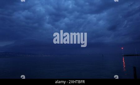 Deutschland kommt nicht zur Ruhe. Abermals sind schwere Gewitter und Unwetter über Süddeutschland hinweggezogen. Am Abend formierte sich am Bodensee eine massive Gewitterfront und fegte einmal komplett über Baden-Württemberg und Südbayern hinweg. Gegen 21 Uhr leuchteten die Sturmwarnleuchten am Bodensee, warnen für einen aufziehenden Unwetter. Dennoch ließ sich eine Schwimmerin von der nahenden Gefahr nicht abhalten. Im Zeitraffer und intensive Blitze sah man eindrucksvoll die Macht der heranziehenden Unwetter. Bei Leutkirch im Allgäu entluden sich anschließend die aufziehenden Unwetter. Schwe Stockfoto