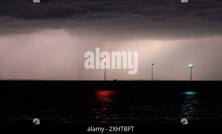 Deutschland kommt nicht zur Ruhe. Abermals sind schwere Gewitter und Unwetter über Süddeutschland hinweggezogen. Am Abend formierte sich am Bodensee eine massive Gewitterfront und fegte einmal komplett über Baden-Württemberg und Südbayern hinweg. Gegen 21 Uhr leuchteten die Sturmwarnleuchten am Bodensee, warnen für einen aufziehenden Unwetter. Dennoch ließ sich eine Schwimmerin von der nahenden Gefahr nicht abhalten. Im Zeitraffer und intensive Blitze sah man eindrucksvoll die Macht der heranziehenden Unwetter. Bei Leutkirch im Allgäu entluden sich anschließend die aufziehenden Unwetter. Schwe Stockfoto