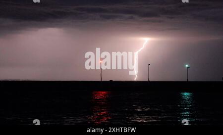 Deutschland kommt nicht zur Ruhe. Abermals sind schwere Gewitter und Unwetter über Süddeutschland hinweggezogen. Am Abend formierte sich am Bodensee eine massive Gewitterfront und fegte einmal komplett über Baden-Württemberg und Südbayern hinweg. Gegen 21 Uhr leuchteten die Sturmwarnleuchten am Bodensee, warnen für einen aufziehenden Unwetter. Dennoch ließ sich eine Schwimmerin von der nahenden Gefahr nicht abhalten. Im Zeitraffer und intensive Blitze sah man eindrucksvoll die Macht der heranziehenden Unwetter. Bei Leutkirch im Allgäu entluden sich anschließend die aufziehenden Unwetter. Schwe Stockfoto