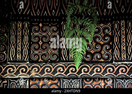 Farnblatt und dekoratives Gemälde in traditionellem Motiv an der Wand einer Reisscheune im Dorf Kete Kesu, Nord-Toraja, Süd-Sulawesi, Indonesien. Stockfoto
