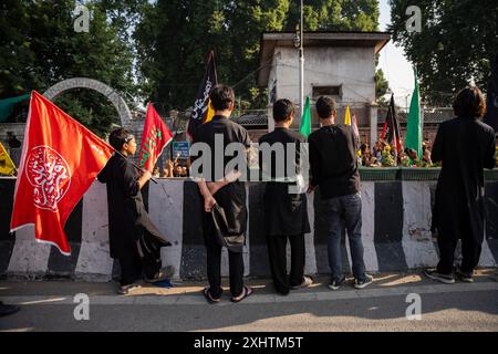 Kaschmiri schiitische Muslime beobachten, wie Trauernde während einer Muharram-Prozession am achten Tag des Muharram gehen. Im zweiten Jahr in Folge erlaubte die Regierung von Jammu und Kaschmir die 8. Muharram-Prozession vom Guru-Basar nach Dalgate in Srinagar. Trotz eines seit langem bestehenden Verbots hielten die schiitischen Muslime weiterhin Prozessionen auf dem 8. Und 10. Muharram entlang dieser Routen ab, die oft mit Polizeieingriffen konfrontiert waren. Die diesjährige Prozession war ein bedeutendes und friedliches Gedenken an das Martyrium von Hazrat Imam Hussainís (AS), das Tausende von Trauernden anzog. Die Prozession, verboten für mehr als drei Deca Stockfoto