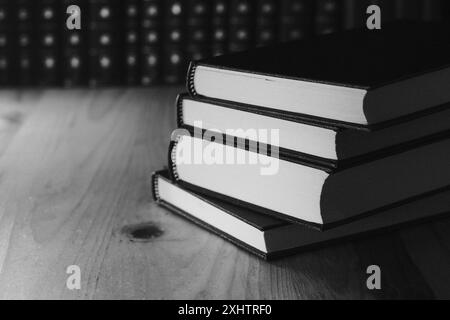 Bücher auf einem Holztisch schwarz-weiß Stockfoto