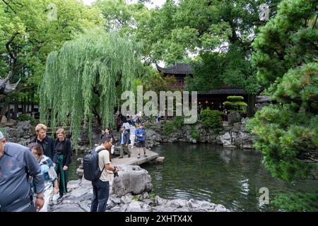 Shanghai, China - 06. Juni 2024 : Ein ruhiger Teich umgeben von üppigem Grün und Steinwegen im Yu Garden, Shanghai, China. Stockfoto