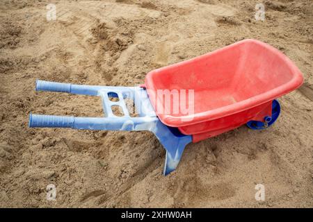 Plastikspielkarre im Sandkasten draußen Stockfoto