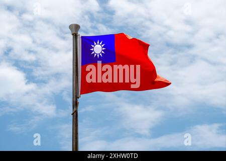 Taiwan-Flagge auf dem Hintergrund des blauen Himmels. Nahaufnahme von Taiwans schwenkender Flagge. Flaggensymbole für Taiwanesisch. Stockfoto