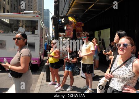 New York, Usa. Juli 2024. Während der dritten Hitzewelle des Sommers in Manhattan, New York City, stehen Menschen auf der Straße. Die New Yorker erleben in den 90er Jahren hohe Temperaturen und feuchtes Wetter, das das Wetter heißer macht. Wetterempfehlungen drängen die Menschen, kühl zu bleiben und bei heißem Wetter mit Feuchtigkeit zu versorgen. (Foto: Jimin Kim/SOPA Images/SIPA USA) Credit: SIPA USA/Alamy Live News Stockfoto