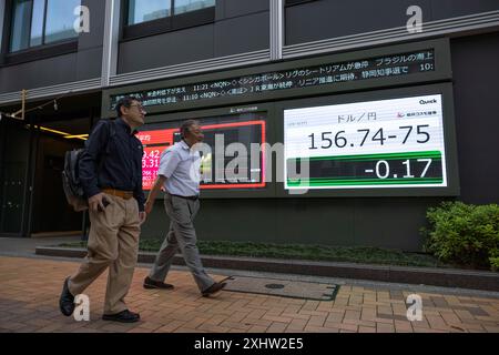 Tokio, Japan. Mai 2024. Männer gehen an einer elektronischen Platine vorbei, auf der Wirtschaftsdaten angezeigt werden. Tokio, 27. Mai 2024. - 20240527 PD13845 Credit: APA-PictureDesk/Alamy Live News Stockfoto