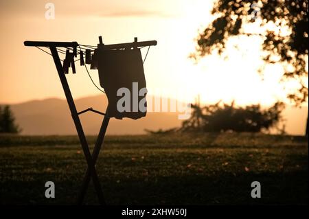 Das T-Shirt wird bei Sonnenuntergang auf einem Wäscheständer getrocknet Stockfoto