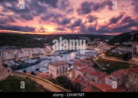 Bonifacio, Korsika, Frankreich - 29. Mai 2024: Ein dramatischer Sonnenaufgang über dem Hafen und den Gebäuden von Bonifacio auf der Insel Korsika Stockfoto