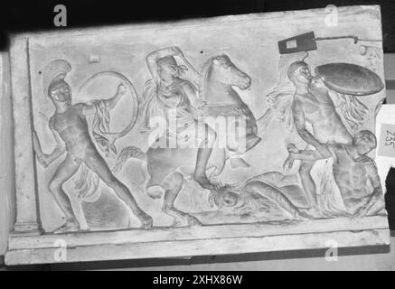 Relief mit einer langen Seite eines Sarkophags, der eine Schlacht zwischen Amazonen und Griechen zeigt, und Figuren, Waffen und dynamische Komposition veranschaulicht. Stockfoto