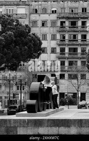 Monochrome Touristen posieren für ein Foto, während sie mit den großen Buchstaben der Stadt im Câmara Municipal do Porto interagieren Stockfoto