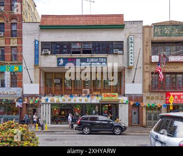 NYC Chinatown: Privater Club, Tanzstudio und Restaurant in einem weißen Backsteingebäude, das von einem roten Fliesendach im Pagodenstil bedeckt ist. Stockfoto