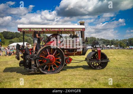 Parham / Großbritannien - 13. Juli 2024: Eine kohlebefeuerte Dampfwalze mit einem kleinen Jungen auf der Fußplatte bei Sussex Steam Rally, Storrington, Großbritannien. Stockfoto