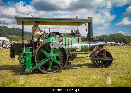 Parham / Großbritannien - 13. Juli 2024: Ein 1936 dampfbetriebener Aveling-Barford Road Roller wird von einem jungen Jungen auf der Sussex Steam Fair in Storrington, Großbritannien, gefahren. Stockfoto