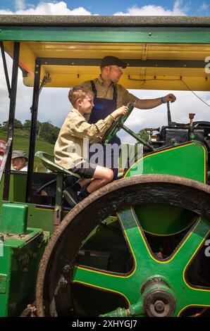 Parham / Großbritannien - 13. Juli 2024: Ein 1936 dampfbetriebener Aveling-Barford Road Roller wird von einem jungen Jungen auf der Sussex Steam Fair in Storrington, Großbritannien, gefahren. Stockfoto