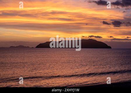 Sonnenaufgang über Shoe Island (Motuhoa) direkt vor der Küste von Tairua Beach und Mount Paku auf der Coromandel Halbinsel auf der Nordinsel Neuseelands Stockfoto