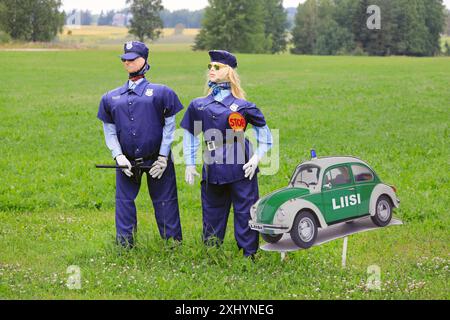 Humorvolle Arrangements mit männlichen und weiblichen Polizeifiguren und ein Bild eines VW-Käfer-Sonderpolizeiwagens. Salo, Finnland. Juli 2024. Stockfoto