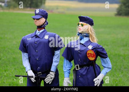 Humorvolles Stillleben mit männlichen und weiblichen Polizeifiguren, die eine Sonnenbrille tragen und einen Stoppstab und ein Stoppschild halten. Salo, Finnland. Juli 2024. Stockfoto