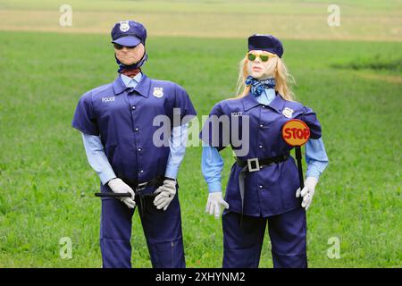 Humorvolle Abmachung mit männlichen und weiblichen Polizeifiguren, die eine Sonnenbrille tragen und einen Schlagstock und ein Stoppschild halten. Salo, Finnland. Juli 2024. Stockfoto