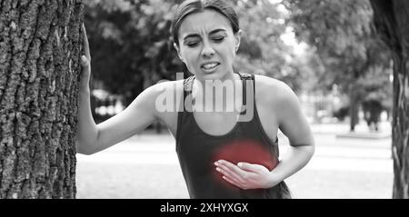 Herzinfarkt. Junge Frau, die unter Schmerzen in der Brust leidet und sich draußen auf einen Baum lehnt. Bannerdesign Stockfoto