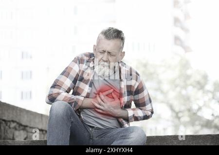 Herzinfarkt. Reifer Mann mit Schmerzen in der Brust im Freien Stockfoto