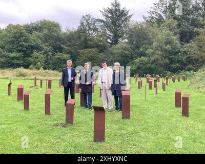 16. Juli 2024, Schleswig-Holstein, Schwesing: Burkhard Jansen, Leiter der Kulturabteilung des Landkreises Nordfriesland, Landrat Florian Lorenzen, Wilfried Christiansen, stellvertretender Vorsitzender der KZ-Gedenkstätte Freunde Husum-Schwesing, und Friedemann Magaard, Vorsitzender der Freunde (von links nach rechts), stehen auf einem Stelenfeld auf dem Gelände des ehemaligen Vorlagers. Die Gefangenen mussten von Ende September 1944 bis Ende Dezember 1944 13 Wochen lang Panzerabwehrgräben ausheben. Mehr als 300 von ihnen starben. Das 13-Wochen-Projekt wurde zur Feier gestartet Stockfoto