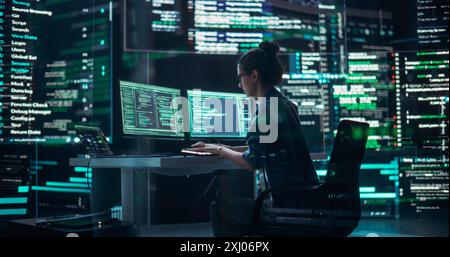 Weibliche Entwicklerinnen denken und tippen am Computer, umgeben von großen Bildschirmen, die Coding Language zeigen. Professioneller Programmierer, Der Software Erstellt Und Codierungstests Durchführt. Futuristisches Programmierungskonzept Stockfoto