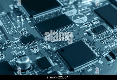 Detaillierte Nahaufnahme einer elektronischen Leiterplatte mit Mikrochips, Widerständen und anderen Komponenten, die moderne Technologie und Hardware repräsentieren. Stockfoto