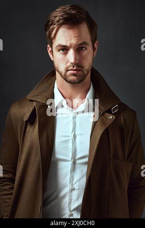 Seriös, Mann und Porträt mit Mode im Studio für stilvolles Outfit, Selbstvertrauen und Zufriedenheit. Designer-Mantel, Hemd und Gesicht einer Person mit Stolz Stockfoto