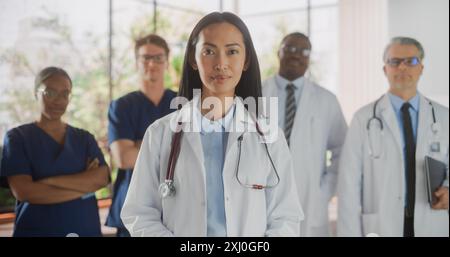 Gruppe von glücklichen multiethnischen Team von weiblichen und männlichen Ärzten, Krankenschwestern und medizinischen Fachleuten posiert für Kamera und Lächeln. Porträt eines zuversichtlichen asiatischen Arztes, der im Fokus steht Stockfoto
