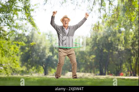 Porträt eines aufgeregten älteren Mannes, der draußen einen Hula Hoop dreht Stockfoto