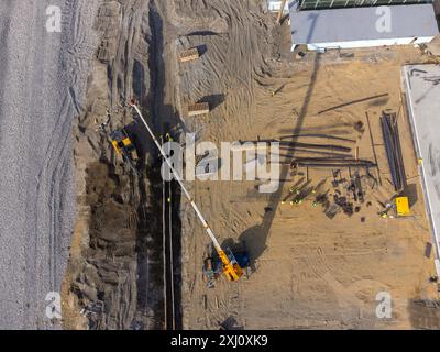 Bauarbeiten an der Küste. Schwere Maschinen arbeiten, um das Fundament vor Wasser und Sturmwellen zu stärken. Blick von der Drohne. Stockfoto