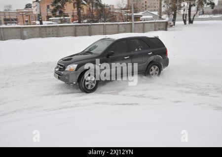 Winterblizzard. Schwarzer SUV, Powerslide auf Schnee – geringe Traktion. Stockfoto