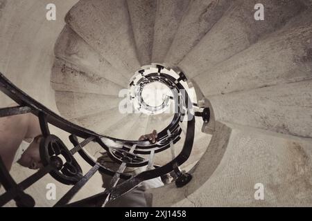 Alte Steintreppe in einem Turm - Blick von unten. Perspektivische Sicht auf die runde Treppe im Uhrzeigersinn. Stockfoto