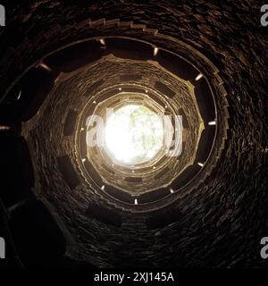 Invertierter Turm in Quinta da Regaleira. Ansicht nach oben von der Unterseite der Initiationsbohrung. Ich schaue durch den Brunnen auf das Licht. Stockfoto