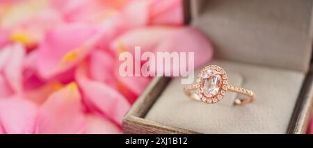 Eleganter Hochzeit Diamant Ring in Schmuckschatulle auf schönem rosafarbenen Rosenblütenhintergrund Nahaufnahme Stockfoto